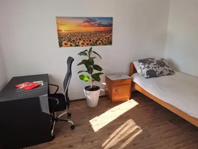 a room with a bed and a desk with a plant at Rural Retreat- Kmečki oddih in Poljčane