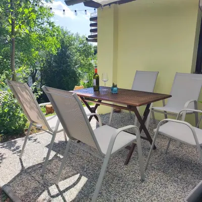 a wooden table and chairs on a patio at Rural Retreat- Kmečki oddih in Poljčane