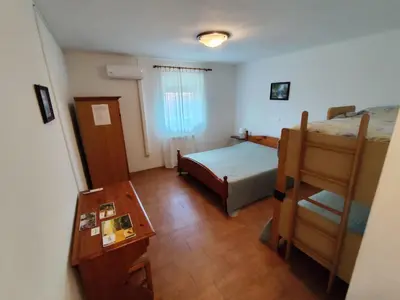 a small bedroom with a bed and a table at Agritourism Kren in Dobrovo