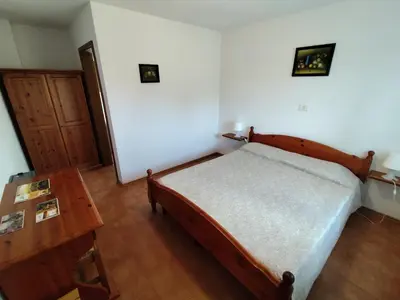 a bedroom with a bed and a wooden table at Agritourism Kren in Dobrovo