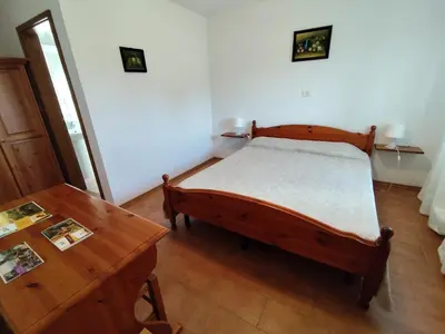a bedroom with a bed and a wooden table at Agritourism Kren in Dobrovo