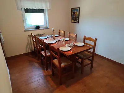a wooden dining room table with chairs and plates on it at Agritourism Kren in Dobrovo
