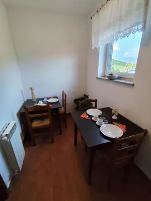 a dining room with a table and chairs and a window at Agritourism Kren in Dobrovo