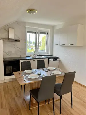 a kitchen with a wooden table with chairs and a dining room at Apartment Emona in Ljubljana