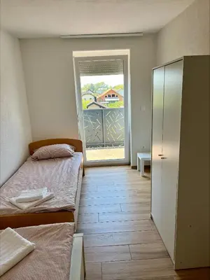 a bedroom with two beds and a door to a balcony at Apartment Emona in Ljubljana