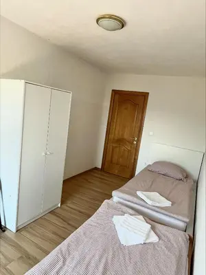 a bedroom with two beds and a cabinet and a door at Apartment Emona in Ljubljana