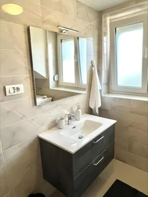 a bathroom with a sink and a mirror at Apartment Emona in Ljubljana