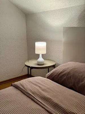 a lamp sitting on a table next to two beds at Apartment Emona in Ljubljana