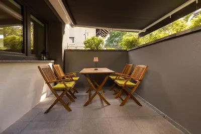 a patio with a table and chairs on a balcony at Apartmaji Klavdija in Ljubljana