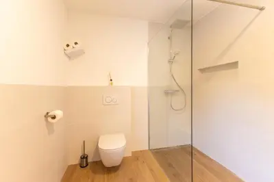 a bathroom with a toilet and a glass shower at Apartmaji Klavdija in Ljubljana