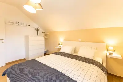 a bedroom with a bed and two lights on at Apartmaji Klavdija in Ljubljana