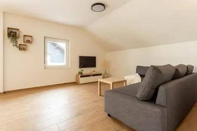 a living room with a couch and a tv at Apartmaji Klavdija in Ljubljana