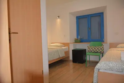 a bedroom with two beds and a window and a chair at Vila Borealis in Komen