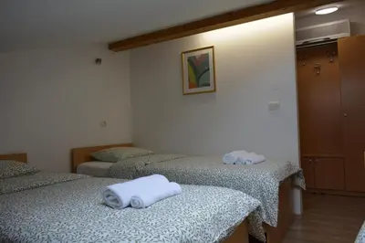 a room with three beds with towels on them at Vila Borealis in Komen