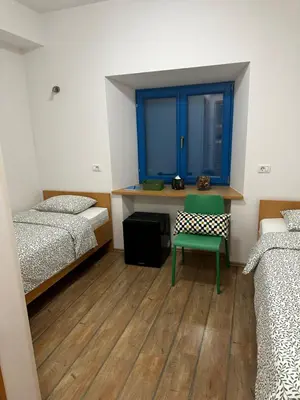 a room with two beds and a desk with a green chair at Vila Borealis in Komen