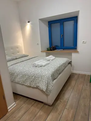 a bedroom with two beds and a blue window at Vila Borealis in Komen
