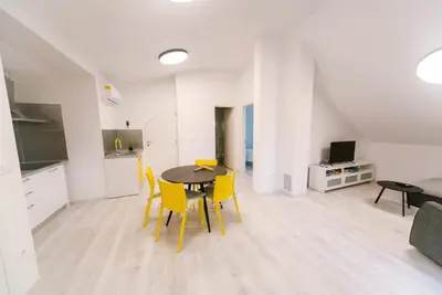 a kitchen and dining room with a table and yellow chairs at Apartma RO-ZE in Bistrica ob Sotli