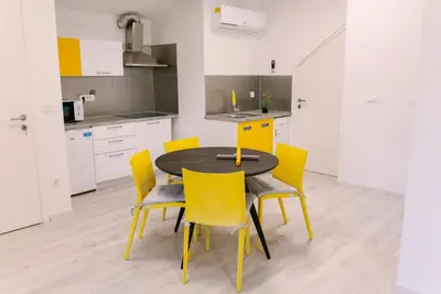 a kitchen with a black table and yellow chairs at Apartma RO-ZE in Bistrica ob Sotli