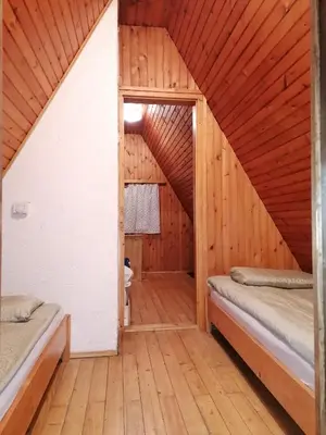a room with two beds in a wooden house at Cottage Koča Oaza Preske in Jurklošter