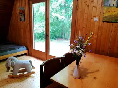 a wooden table with a vase of flowers on top of it at Cottage Koča Oaza Preske in Jurklošter