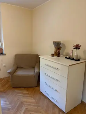 a white dresser and a chair in a room at Janko's house in Maribor