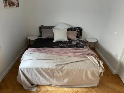 a bedroom with a large bed with two tables at Janko's house in Maribor