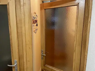 a wooden door with a glass window in a bathroom at Janko's house in Maribor