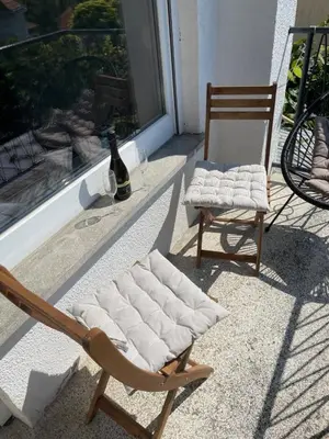 two chairs sitting on a porch next to a window at Janko's house in Maribor