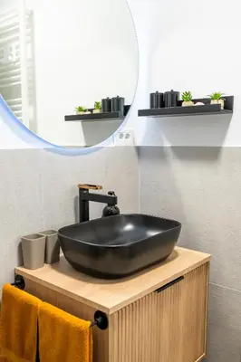 a bathroom with a black sink and a mirror at Private House - Serenity home in Lokev