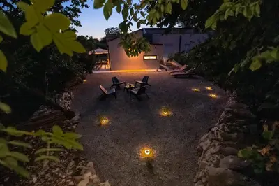 an outdoor patio with benches and lights at night at Private House - Serenity home in Lokev