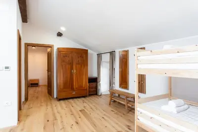 a bedroom with a bunk bed and wooden floors at Wellba Homestead Planina in Ajdovščina