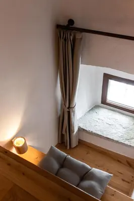 a room with a window with a couch in front of it at Wellba Homestead Planina in Ajdovščina