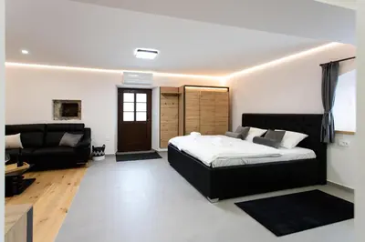 a bedroom with a bed and a living room at Wellba Homestead Planina in Ajdovščina