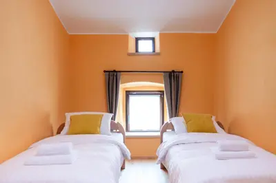 two beds in a room with a window at Wellba Homestead Planina in Ajdovščina