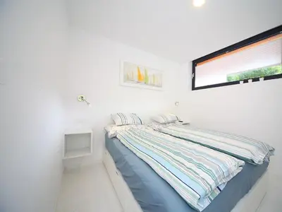 a bed in a white room with a window at Vila Edelweiss Rooms&App Kranjska Gora in Kranjska Gora