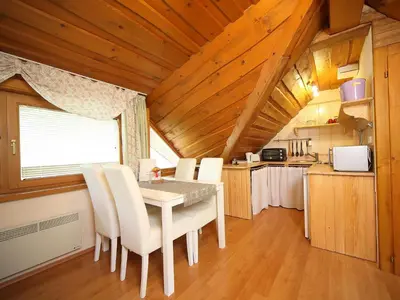 a dining room with a table and white chairs at Vila Edelweiss Rooms&App Kranjska Gora in Kranjska Gora