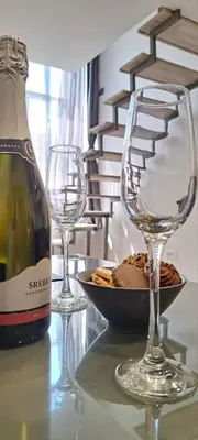 a bottle of wine and two wine glasses on a table at Ljubljana Nest- centre, free parking- renovated August 2024 in Ljubljana