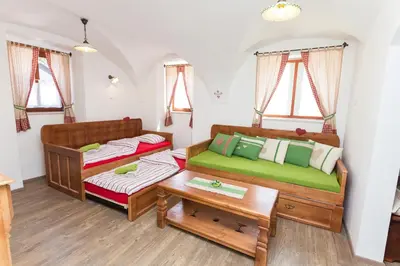 a room with two twin beds and a table at Apartments Petacova Hiša in Kranjska Gora