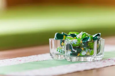 a small glass bowl of candy on a table at Apartments Petacova Hiša in Kranjska Gora