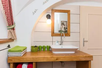 a bathroom with a sink and a mirror at Apartments Petacova Hiša in Kranjska Gora