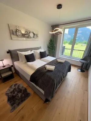 a large bed in a room with a large window at Riverstone Retreat Bovec in Bovec