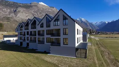 an aerial view of a building with mountains in the background at Riverstone Retreat Bovec in Bovec