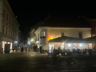 a group of people walking down a street at night at Studio Old Town in Maribor