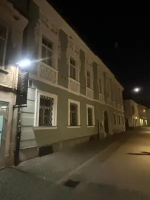 a building with a light on the side of it at night at Studio Old Town in Maribor
