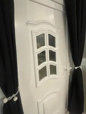 a white door with a window and black curtains at Studio Old Town in Maribor