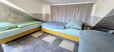 a room with two beds and a window at Bled Lesce station rooms and depo in Lesce