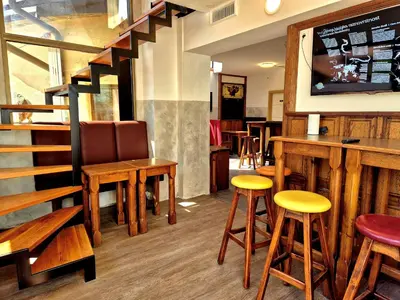 a bar with wooden stools and a tv at Bled Lesce station rooms and depo in Lesce