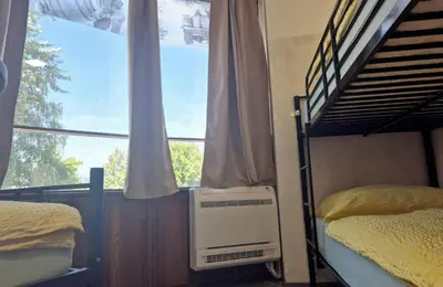 a bedroom with two bunk beds and a window at Bled Lesce station rooms and depo in Lesce