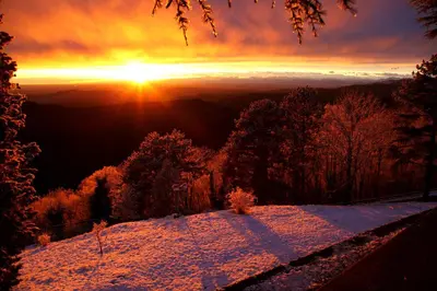 a sunset in the mountains with snow on the ground at Podgozd Holiday House in Trnovo