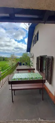 a patio with two benches on a balcony at Podgozd Holiday House in Trnovo